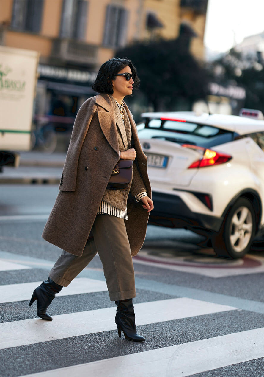 Frau trägt beigen, monochromen Look mit Wollmantel, Stoffhose und Stiefeletten