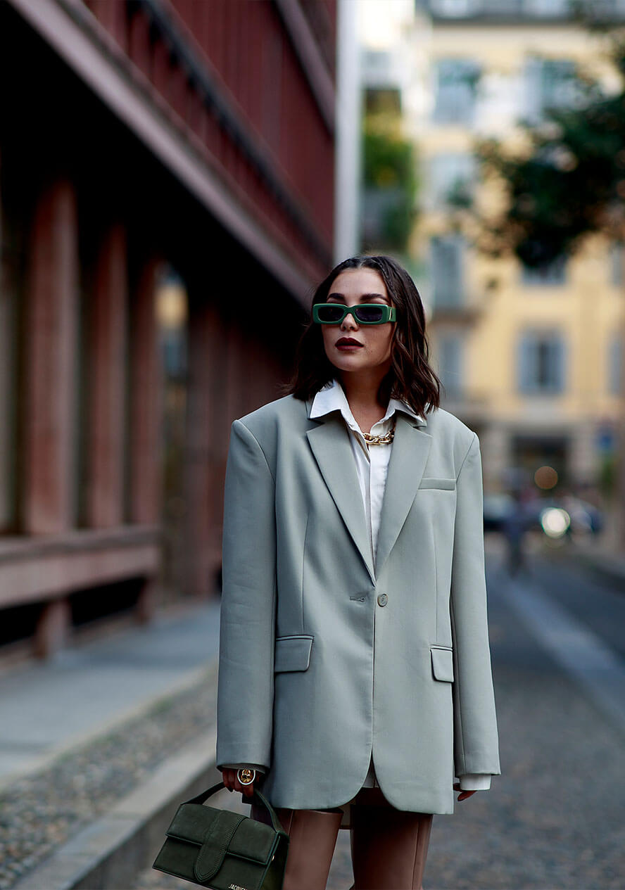 Frau trägt einen Oversized Blazer in Grau zu Rock und Bluse