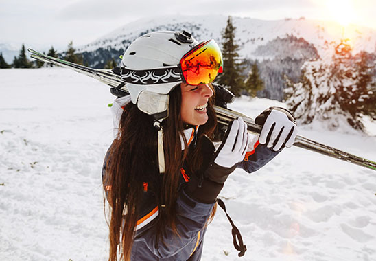 Frau mit Skiern auf der Piste